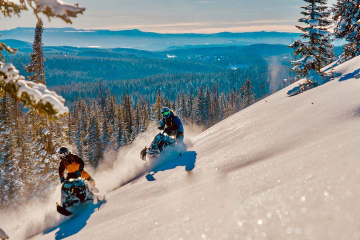 a man riding a snowboard down a snow covered slope