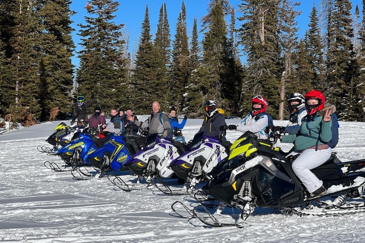 a group of people riding skis down a snow covered slope